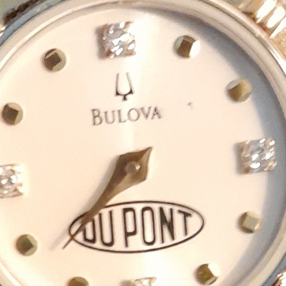 Bulova watch with "DUPONT" branding, featuring four diamond hour markers